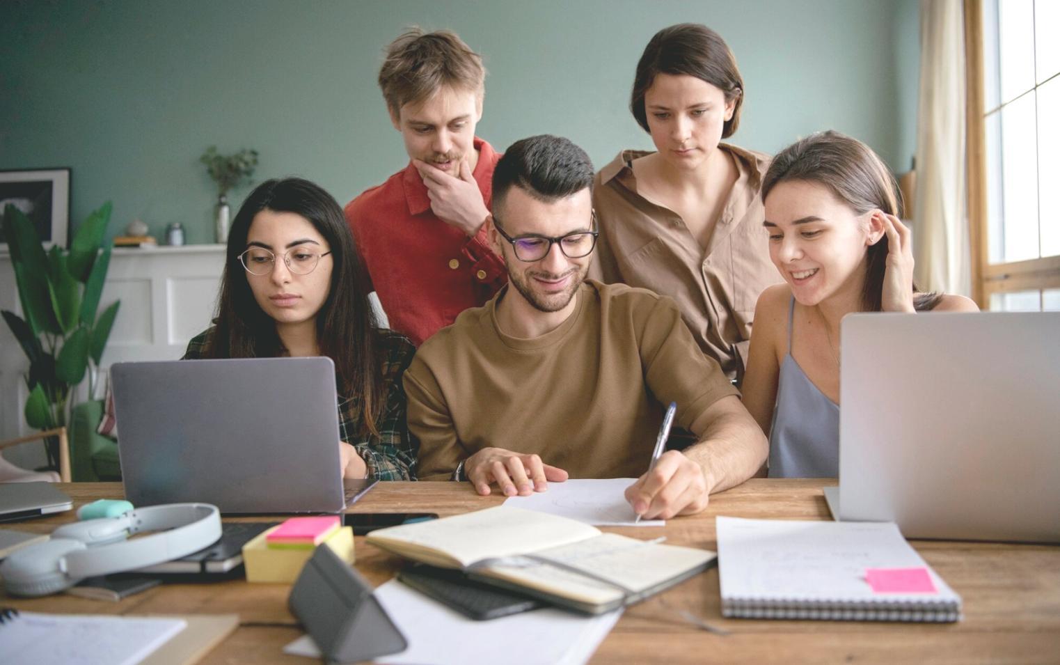 Profesionales analizando gráficos económicos y datos financieros en entorno de aprendizaje colaborativo